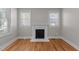 Bright living room featuring hardwood floors, fireplace, and natural light from two windows with blinds at 1811 Ridley St, Raleigh, NC 27608
