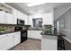 Bright kitchen with white cabinets, black appliances, and a view into the living area at 1821 Kelly Glen Dr, Apex, NC 27502