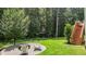 Landscaped backyard with fire pit and Adirondack chairs offers a serene outdoor space at 186 Ross Dr, Pittsboro, NC 27312