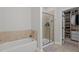 Bathroom featuring a bathtub, glass shower, and walk-in closet with custom shelving at 186 Ross Dr, Pittsboro, NC 27312
