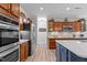 Well-equipped kitchen with stainless steel appliances, wood cabinets, quartz countertops, and large center island at 186 Ross Dr, Pittsboro, NC 27312