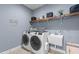 Functional laundry room with a new washer and dryer, sink, storage and decorative wall art at 186 Ross Dr, Pittsboro, NC 27312