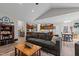 Inviting living room featuring a comfortable gray sofa, a fireplace, and an open layout to the kitchen and dining area at 186 Ross Dr, Pittsboro, NC 27312