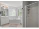 Bright bathroom featuring a corner tub, glass block window, and a glass shower door at 1990 Ferbow St, Creedmoor, NC 27522