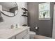 Bathroom featuring a black round mirror, floating shelves, and neutral walls at 1990 Ferbow St, Creedmoor, NC 27522