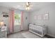 This bedroom features a white baby crib, a changing table, and natural light at 1990 Ferbow St, Creedmoor, NC 27522