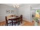 Traditional dining room features hardwood floors, modern chandelier, and six-chair wood table at 1990 Ferbow St, Creedmoor, NC 27522