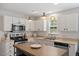 Bright and functional kitchen with stainless appliances, white cabinets, and a stylish island for prepping and dining at 1990 Ferbow St, Creedmoor, NC 27522