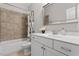 Elegant bathroom featuring a shower-over-tub and a white vanity with a marble countertop and framed mirror at 220 W Winmore Ave, Chapel Hill, NC 27516