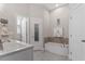 Bright bathroom with a marble vanity, tub with tile accents, and a separate shower door at 220 W Winmore Ave, Chapel Hill, NC 27516