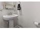 Elegant bathroom with a pedestal sink, a modern faucet, and a decorative mirror shelf at 220 W Winmore Ave, Chapel Hill, NC 27516