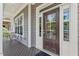 Inviting front porch with a wooden deck, dark brown door, and views of surrounding greenery at 220 W Winmore Ave, Chapel Hill, NC 27516