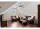 Upstairs living room features hardwood floors, a ceiling fan, and comfortable seating with natural light at 220 W Winmore Ave, Chapel Hill, NC 27516