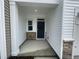 Inviting front porch with stone accents, white siding, and a modern black front door at 231 Paramount Dr, Smithfield, NC 27577