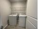 Well-lit laundry room featuring a washer, dryer and wire shelving at 231 Paramount Dr, Smithfield, NC 27577