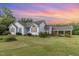 Charming home exterior with blue siding, blue shutters, and a beautiful sunset at 2312 Buckstone Ct, Fuquay Varina, NC 27526