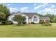 Quaint one-story home with blue shutters and a large tree in the front yard, creating a welcoming ambiance at 2312 Buckstone Ct, Fuquay Varina, NC 27526