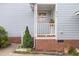 Close-up of a home's brick foundation and a quaint front porch with white railings and a house number at 2312 Buckstone Ct, Fuquay Varina, NC 27526