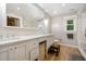 Bathroom featuring dual sinks, wood-look tile, and a large mirror above the vanity at 2409 Basil Dr, Raleigh, NC 27612