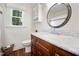 This bathroom boasts beadboard walls, wood-look flooring, a marble countertop, and a decorative mirror at 2409 Basil Dr, Raleigh, NC 27612