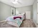 Bedroom features neutral carpet, ceiling fan, a light purple throw and view to outside at 2409 Basil Dr, Raleigh, NC 27612