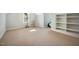 This carpeted bonus room offers plenty of space, a window and built-in shelving at 2409 Basil Dr, Raleigh, NC 27612