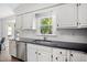 Bright kitchen features white cabinets, stainless steel appliances, and black countertops at 2409 Basil Dr, Raleigh, NC 27612