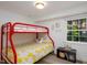 Bedroom featuring a red bunk bed, window with natural light, and a small storage unit for toys at 256 Marilyn Cir, Cary, NC 27513