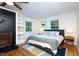 A cozy bedroom featuring a painted fireplace, built-in shelving, and hardwood floors at 256 Marilyn Cir, Cary, NC 27513