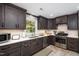 Stylish kitchen boasts dark wood cabinets, quartz counters, and modern appliances at 256 Marilyn Cir, Cary, NC 27513