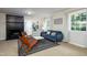 A modern living room with a blue velvet sofa, black fireplace, and unique woven chairs at 256 Marilyn Cir, Cary, NC 27513