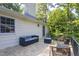 A cozy outdoor patio with wicker furniture and a view of the wooded backyard at 256 Marilyn Cir, Cary, NC 27513
