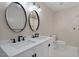 Bright bathroom featuring double sinks, modern lighting, and a walk-in shower at 2609 Elmhurst Cir, Raleigh, NC 27610