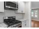 Modern kitchen features stainless steel gas range, microwave, granite counters and patterned backsplash at 2609 Elmhurst Cir, Raleigh, NC 27610