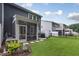 View of the backyard features a screened porch, patio, and well-maintained lawn at 273 Millennium Dr, Pittsboro, NC 27312