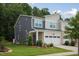 Well-maintained two-story townhouse with brick accents, a two-car garage and green front yard at 273 Millennium Dr, Pittsboro, NC 27312