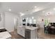 Modern kitchen featuring a central island, stainless steel appliances and an open-concept design to living and dining areas at 273 Millennium Dr, Pittsboro, NC 27312