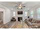 Bright living room with a ceiling fan, fireplace, and large sofa, perfect for relaxation and entertainment at 273 Millennium Dr, Pittsboro, NC 27312