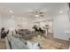 Open-concept living space with hardwood floors, a stylish ceiling fan, and seamless flow into the modern kitchen at 273 Millennium Dr, Pittsboro, NC 27312