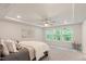 Inviting main bedroom with a tray ceiling, ceiling fan, and ample natural light from large windows, a tranquil retreat at 273 Millennium Dr, Pittsboro, NC 27312