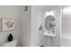 Stylish powder room with pedestal sink, oval mirror, decorative art and a modern toilet at 273 Millennium Dr, Pittsboro, NC 27312