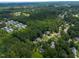 Aerial view shows neighborhood among heavily wooded area and a small lake at 2750 Michelle Ct, Creedmoor, NC 27522