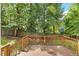 View of the wood back deck overlooking a lush, wooded backyard with a classic wooden fence at 2750 Michelle Ct, Creedmoor, NC 27522