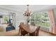 Bright dining room with chandelier, wood table and view of landscaped backyard through large windows at 2750 Michelle Ct, Creedmoor, NC 27522