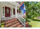 Inviting front porch with brick steps, white railing, and a patriotic flag creating a welcoming entrance at 2750 Michelle Ct, Creedmoor, NC 27522