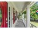 Charming covered front porch with hanging ferns and red shutters creating a cozy outdoor space at 2750 Michelle Ct, Creedmoor, NC 27522