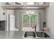 Bright kitchen features a double stainless steel sink with white cabinets and a view to the backyard at 2750 Michelle Ct, Creedmoor, NC 27522