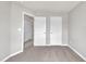 Light-filled bedroom featuring neutral carpet and white paneled doors at 287 White Oak Ridge Dr, Garner, NC 27529