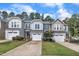 Row of two-story townhomes with attached garages, lush green lawns and blue skies at 287 White Oak Ridge Dr, Garner, NC 27529