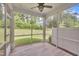 Covered screened porch with tiled flooring, a fan and a view of the lush backyard at 287 White Oak Ridge Dr, Garner, NC 27529
